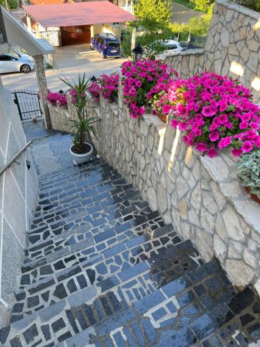 una pared de piedra con flores rosas. en LaCasaBonita en Mostar