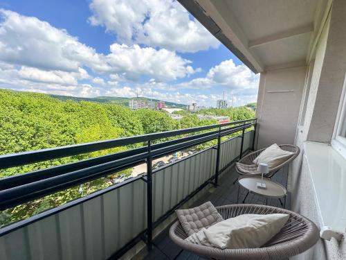 d'un balcon avec deux chaises et une vue sur un train. dans l'établissement Apartmán Simcity Bratislava, à Bratislava