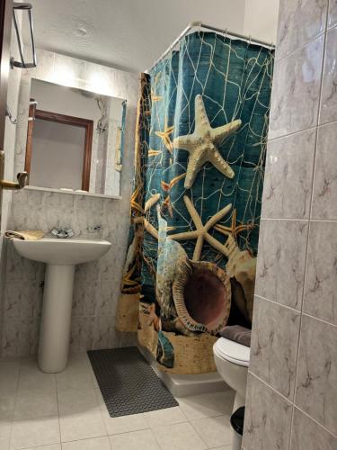 a bathroom with a sink and a starfish shower curtain at Fedra Apartments Lindos in Líndos