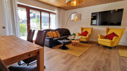 Una sala de estar con un sofá, una mesa y sillas. en Apartment Meertraum Steinhude, en Steinhude