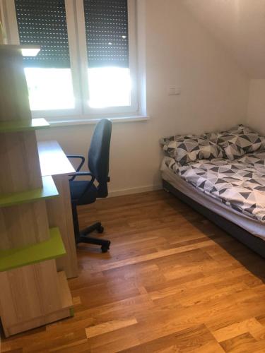 a bedroom with a bed and a desk and a chair at Wypoczynek nad Dunajcem in Jurków