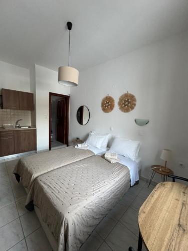 a bedroom with a large bed and a kitchen at Fedra Apartments Lindos in Líndos