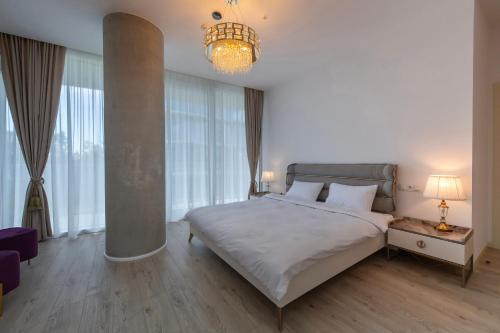 a bedroom with a large bed and a chandelier at Green Cape Botanico in Batumi