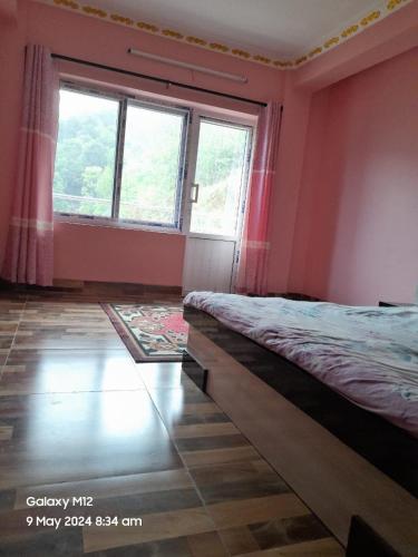 LalitpurにあるGodamchaur Villaのベッドルーム1室(ベッド1台、大きな窓付)
