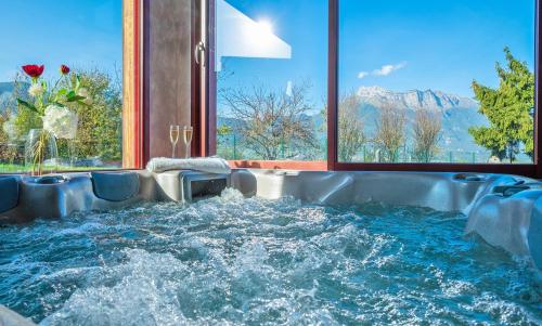 jacuzzi en una habitación con una gran ventana en AlpiZen centre de Ressourcement - Adults recommended, en Coise-Saint-Jean-Pied-Gauthier