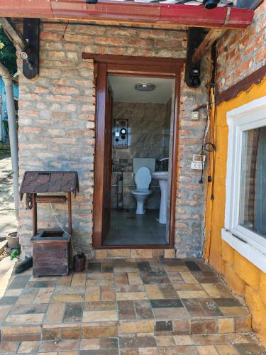 a bathroom with a toilet in a brick wall at La Popica in Tîrnăveni