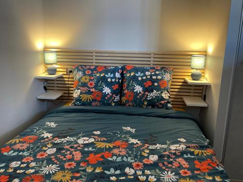 - une chambre avec un lit avec un couvre-lit floral et deux lampes dans l'établissement Sublime T2, entièrement rénové, à Toulouse