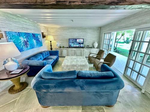 a living room with blue couches and a tv at Mansao Angra Pe na Areia in Angra dos Reis