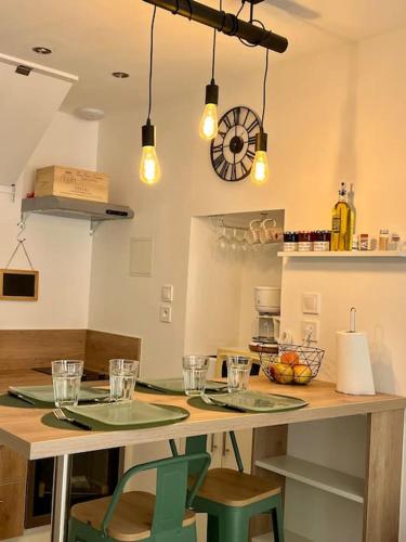 a kitchen with a table with two chairs and lights at Charmante maison de village in Peyriac-de-Mer