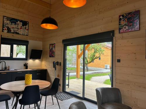 a kitchen and dining room with a table and chairs at Les Chalets près de Chalain in Montigny-sur-lʼAin