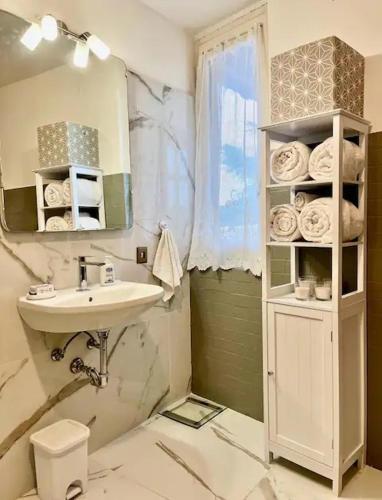 a bathroom with a sink and a toilet and a mirror at Palazzo Mane in CastellʼArquato