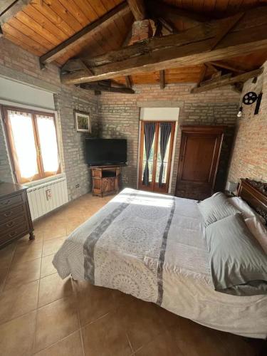 a bedroom with a large bed in a brick wall at Palazzo Mane in CastellʼArquato