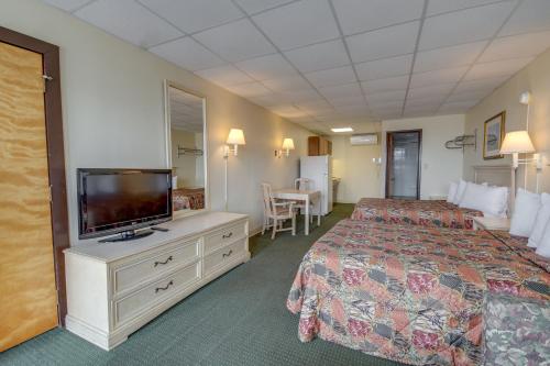 a hotel room with a bed and a flat screen tv at Surf Inn Suites in Ocean City