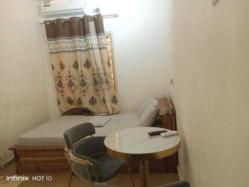 a small room with a bed and a table and chairs at HEBERTOGO Casablanca in Lomé