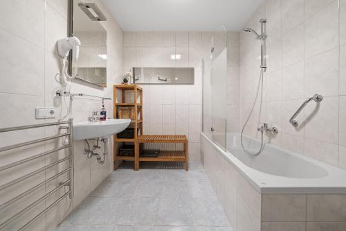 y baño con bañera, lavamanos y ducha. en Appartement Tauernblick Top 6 Kaprun by Four Seasons Apartments, en Kaprun