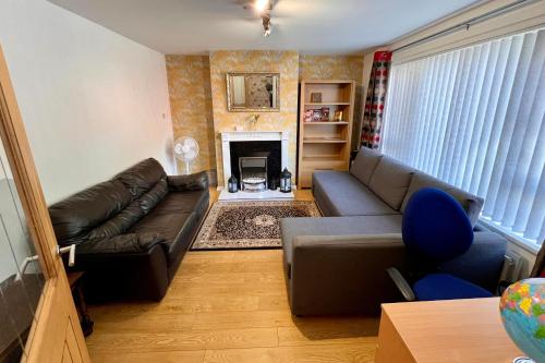a living room with a couch and a fireplace at 3 Bedroom House near city centre in Belfast