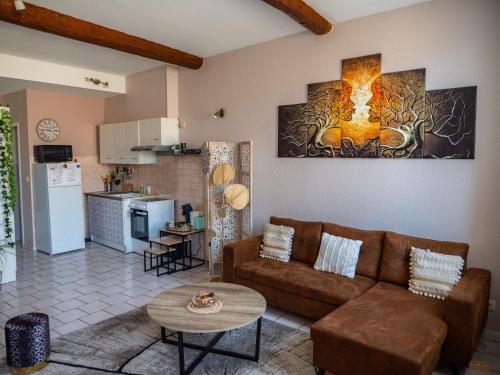 un salon avec un canapé et une cuisine dans l'établissement Maison Chevalier, à Narbonne