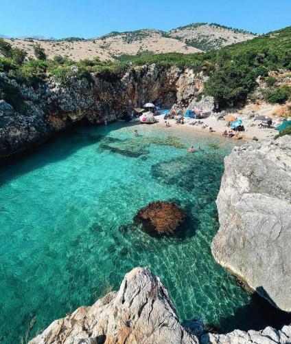 a beach with people swimming in the water at Camping Aquarium in Himare