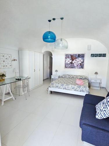 a bedroom with a bed and a blue couch at Maridea - Insvla in Ponza