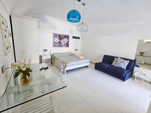 a living room with a bed and a blue couch at Maridea - Insvla in Ponza
