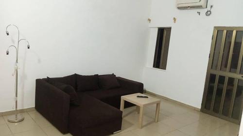 a living room with a black couch and a table at HEBERTOGO Casablanca in Lomé