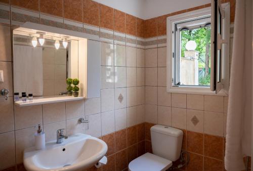 a bathroom with a sink and a toilet and a window at Studio in Corfu in Kanálion
