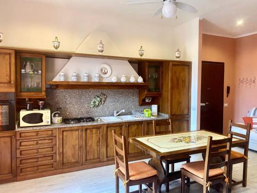 una cocina con armarios de madera y una mesa con sillas. en Barbara's apartment, en Mercatale Val Di Pesa