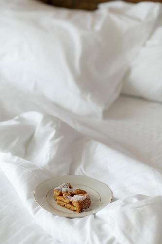 a piece of cake on a plate on a bed at Ca' Nadin Agriturismo in San Damiano dʼAsti