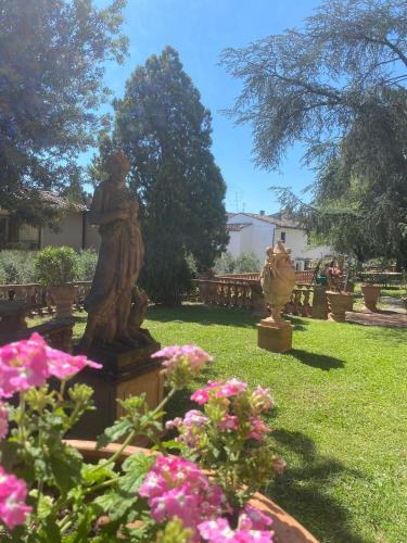 a statue in a garden with pink flowers at Barbara's apartment in Mercatale Val Di Pesa