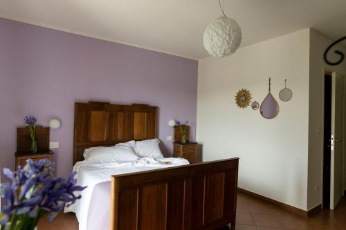 a bedroom with a bed with white sheets and purple walls at Ca' Nadin Agriturismo in San Damiano dʼAsti