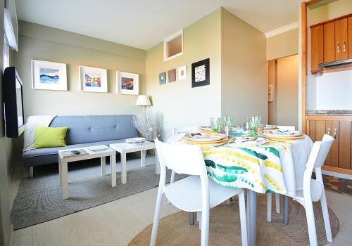 Apartamento con parking en San Vicente في او غروف: غرفة طعام مع طاولة وأريكة