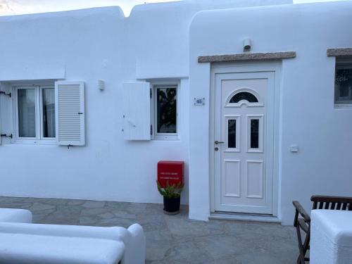 a white house with a white door and a red mailbox at Anais in Mýkonos City