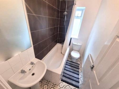 a bathroom with a sink and a toilet and a shower at 3 Bedroom Spacious Modern Comfortable Home in Rochdale, Work, Relax, Explore Manchester, Oldham, Bury in Rochdale