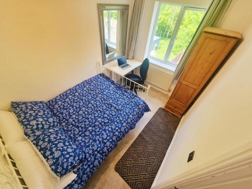 a small bedroom with a bed and a window at 3 Bedroom Spacious Modern Comfortable Home in Rochdale, Work, Relax, Explore Manchester, Oldham, Bury in Rochdale