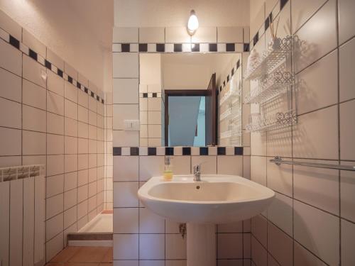 Un baño blanco con lavabo y espejo. en il lago, en Bracciano