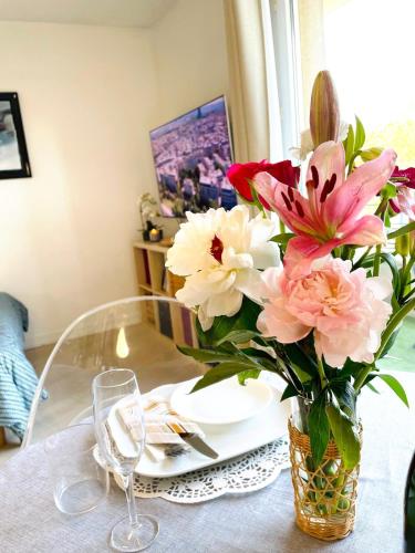a vase filled with pink and white flowers on a table at Studio Ligne 7 : Vision d'avenir in Le Kremlin-Bicêtre