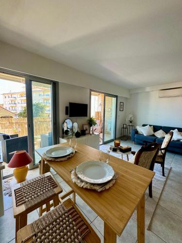 un salon avec une table et des chaises en bois dans l'établissement Charmant Studio terrasse Cannes, à Cannes