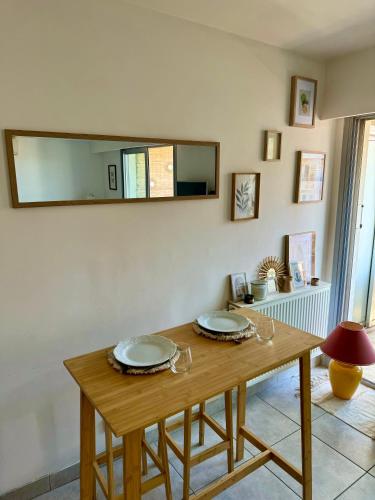 une table en bois avec deux plaques au-dessus dans l'établissement Charmant Studio terrasse Cannes, à Cannes
