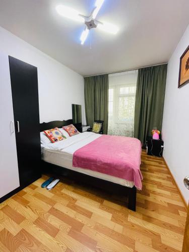 a bedroom with a bed with a pink blanket at Windhorse Tours and Hostel in Ulaanbaatar