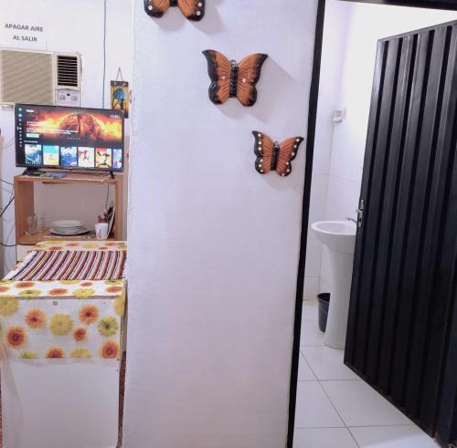 Trzy motyle wiszą na ścianie w łazience. w obiekcie Jasy Hospedaje w mieście Paraguarí