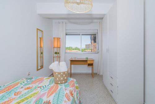 Schlafzimmer mit einem Bett, einem Schreibtisch und einem Fenster in der Unterkunft Delfín Retreat con Terraza junto a parada de Metro in Granada