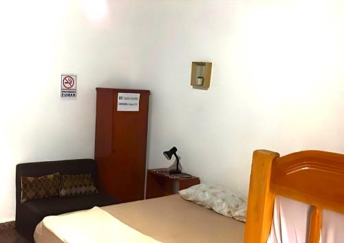 a bedroom with a bed and a cabinet and a lamp at Jasy Hospedaje in Paraguarí