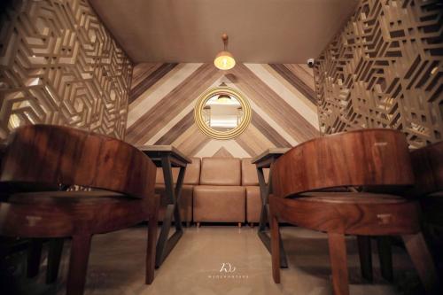a room with two wooden chairs and a couch at Utham Mahal in Anchal
