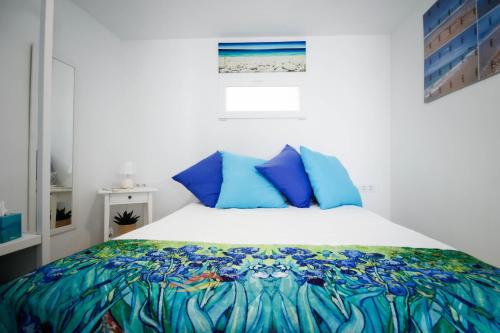 1 dormitorio con 1 cama grande con almohadas azules en Apartamentos Zona Porteta, en Peñíscola