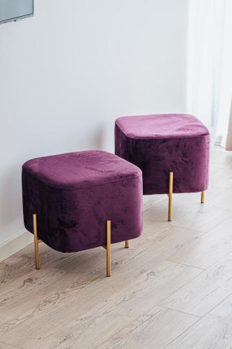a pair of purple ottools sitting on a wooden floor at Green Cape Botanico in Batumi
