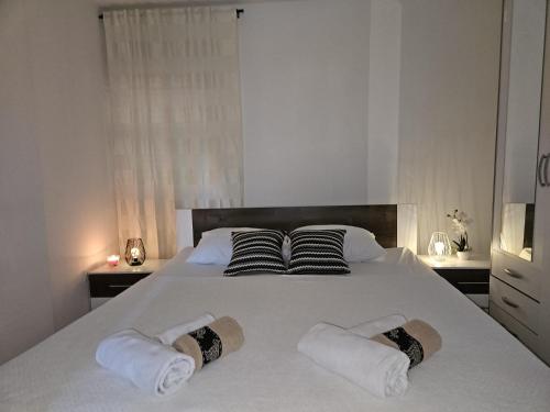 ein Schlafzimmer mit einem weißen Bett mit zwei Kissen in der Unterkunft Blanca in Kaštela
