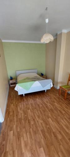 - une chambre avec un lit dans un dortoir doté de parquet dans l'établissement Maison avec garage proche de la plage, à Les Sables-dʼOlonne