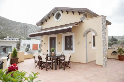 a house with a table and chairs on a patio at Λειτουργικό σπίτι σε κεντρική τοποθεσία in Kalymnos