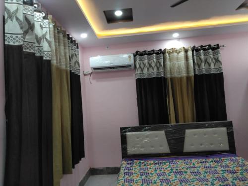 a bedroom with black and yellow curtains and a bed at Shyama Sadan in Ayodhya