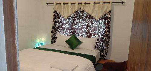 a bedroom with a bed with a black and white headboard at Dreaminn family homestay in Meenangadi